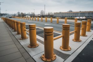 Fixed yellow traffic safety bollards installed along parking lot curb